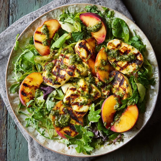 A plate of food with peaches and greens.