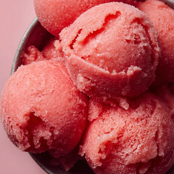 A bowl of red frozen dessert.