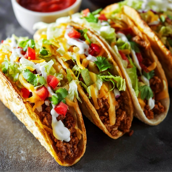 Two tacos with lettuce and cheese.