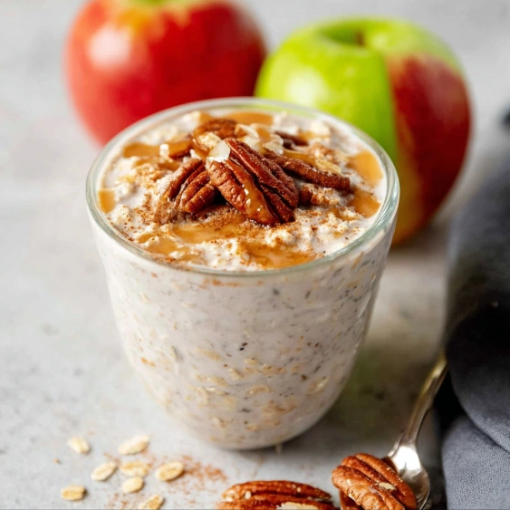 A glass of yogurt with nuts on top.