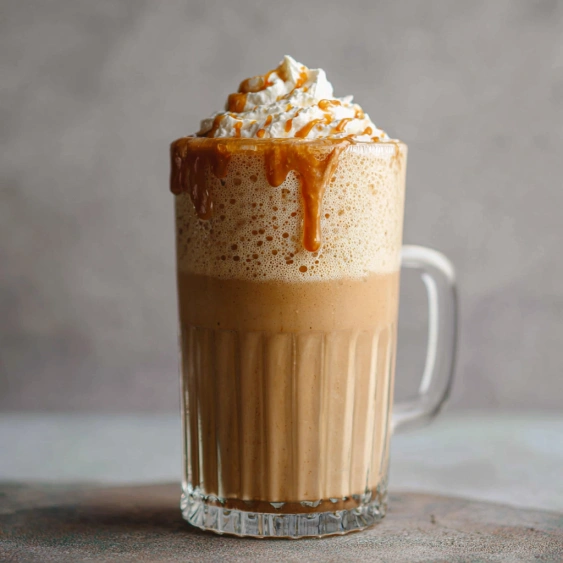 A glass of coffee with whipped cream.