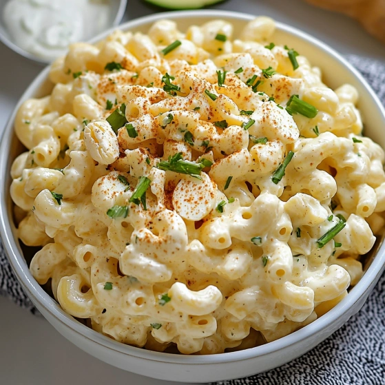 A bowl of macaroni and cheese with green onions.