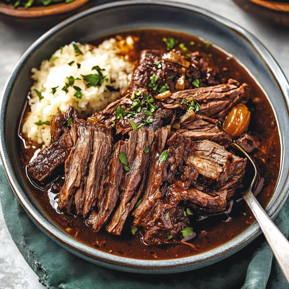 A bowl of beef stew with a spoon.