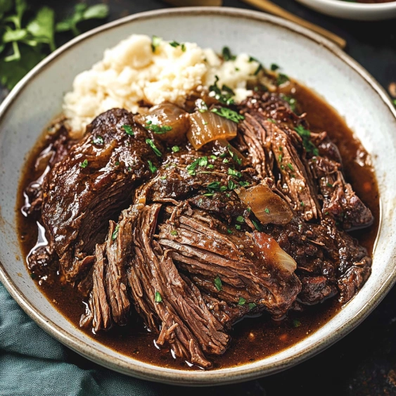 A bowl of beef stew with onions and potatoes.