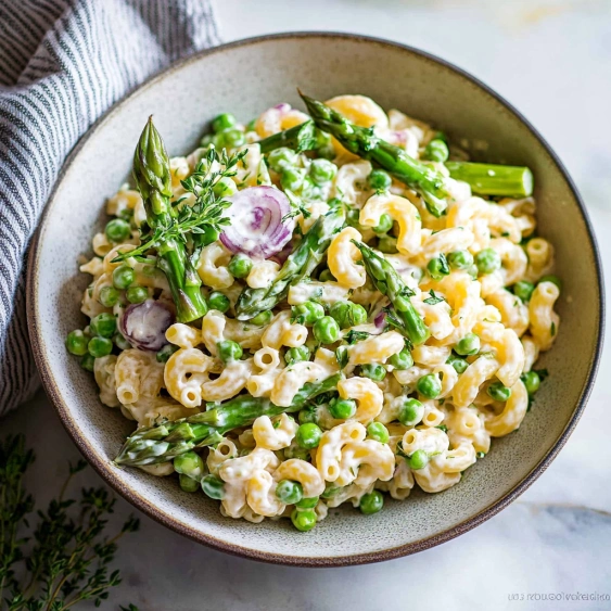 A bowl of pasta with asparagus and peas.