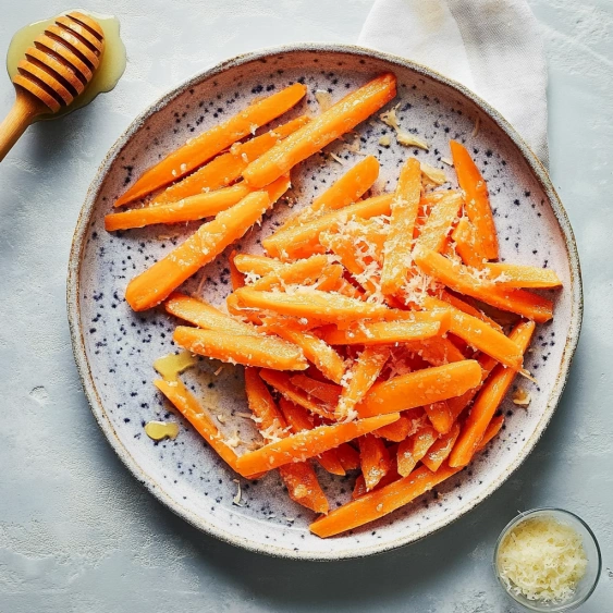A plate of carrots with a honey drizzle.