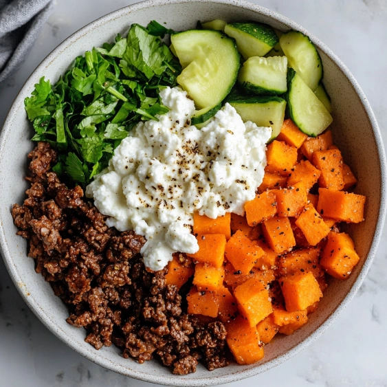 A bowl of food with vegetables and meat.