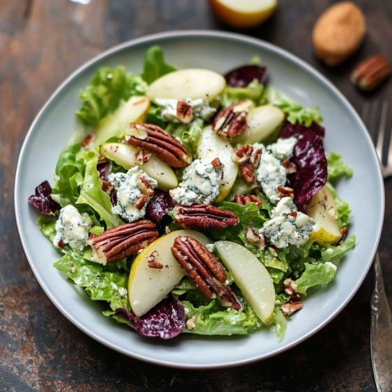 A plate of salad with apples, lettuce, and nuts.