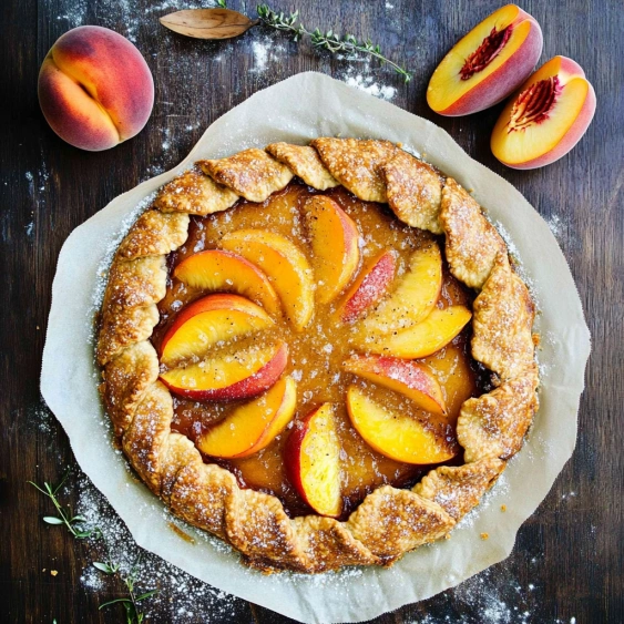 A peach pie with peaches on top.