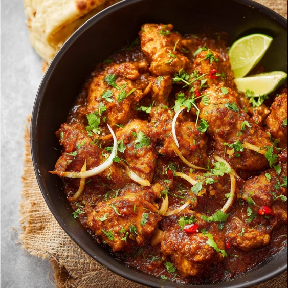 A bowl of chicken with onions and peppers.
