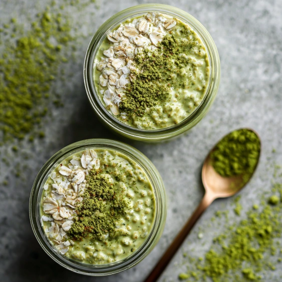 A bowl of granola with green stuff on top.